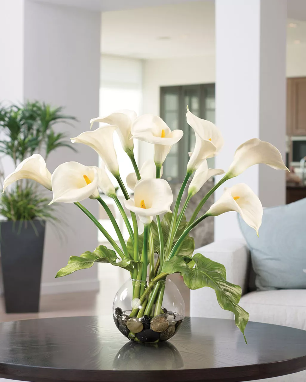 Modern minimalist arrangement with white calla lilies and green tropical leaves